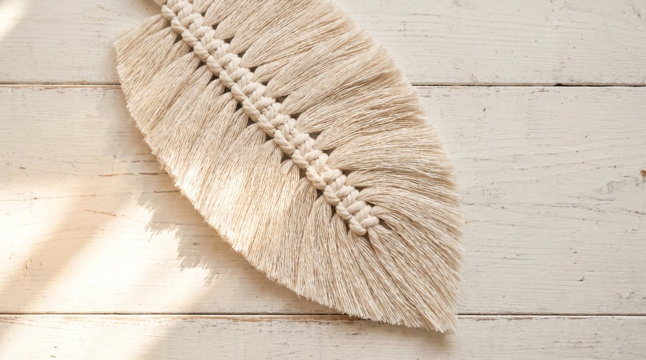 Macrame feather showing quill barbs and tapered tip in twisted cotton cord