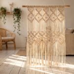 A handmade macrame curtain hanging in a sunlit boho doorway with natural cord