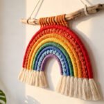 Colourful macrame rainbow wall hanging displayed on a white painted wall