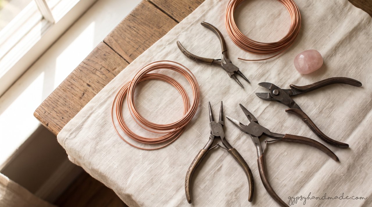 Flat lay of wire wrapping supplies for beginners, including copper wire and pliers.