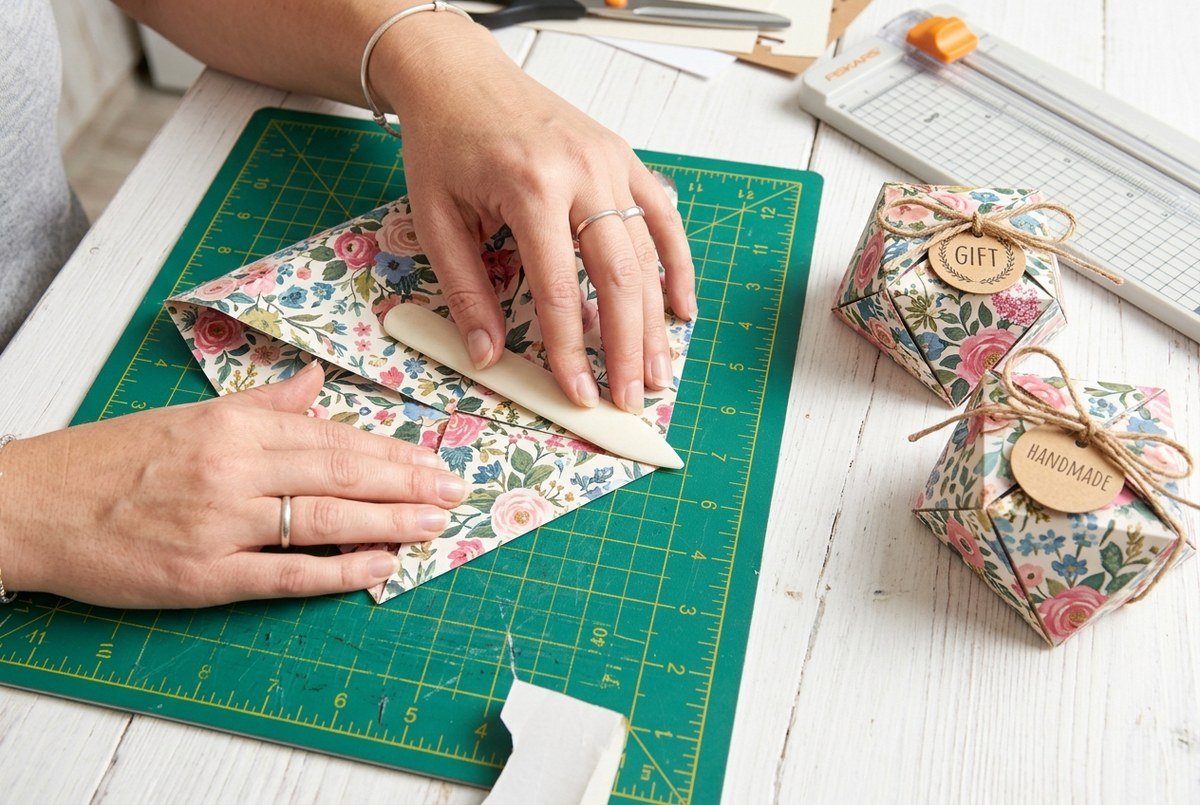 Folding geometric origami gift boxes from 12x12 patterned scrapbooking cardstock with a bone folder